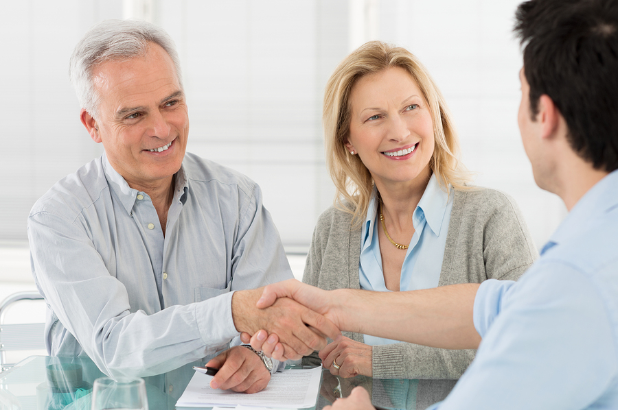 Senior Happy Couple Shaking Hand With Financial Advisor