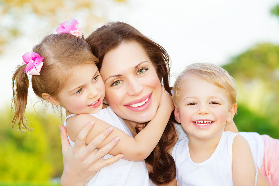 Picture of young mother hugging two little children, closeup por