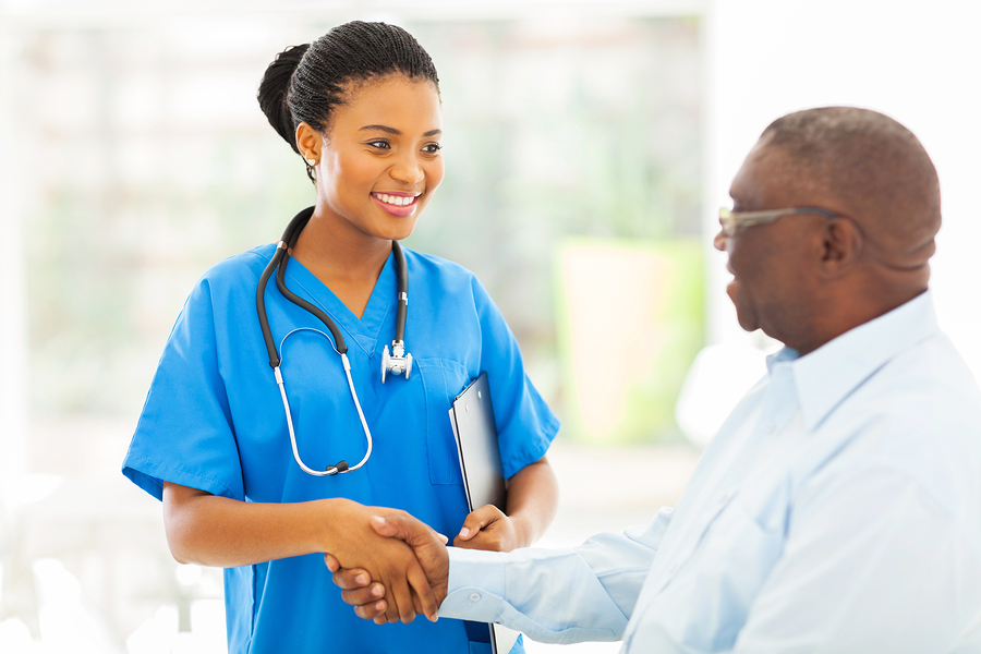 friendly african american medical nurse handshaking with senior